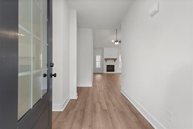 corridor with baseboards and wood finished floors