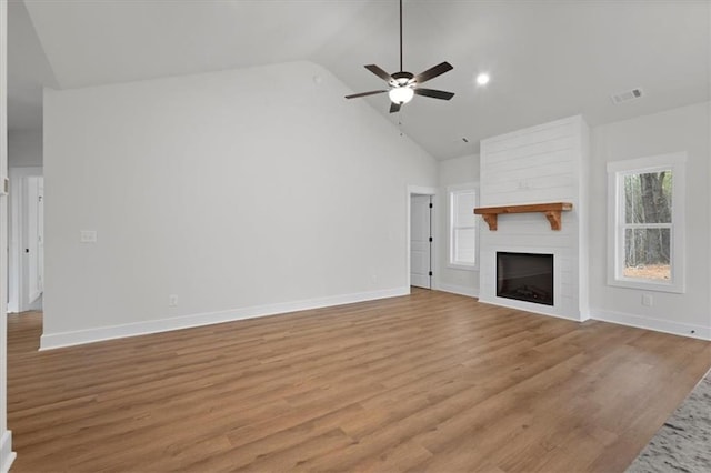 unfurnished living room featuring a ceiling fan, baseboards, visible vents, a fireplace, and light wood-type flooring