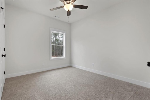 empty room with visible vents, baseboards, a ceiling fan, and carpet flooring