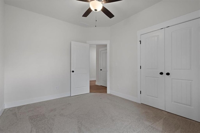 unfurnished bedroom with baseboards, carpet floors, a closet, and a ceiling fan