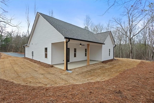 view of property exterior with a patio area, a shingled roof, and ceiling fan