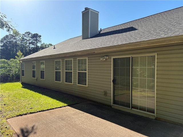 3505 Saddle Creek Ln, Ellenwood, GA 30294 - back of house with a shingled roof, a chimney, a yard, and a patio area