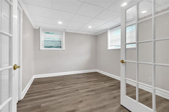 basement with a drop ceiling, hardwood / wood-style flooring, and a wealth of natural light