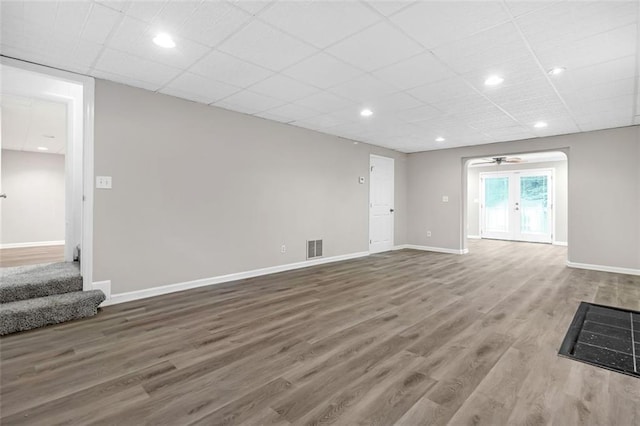 unfurnished living room featuring hardwood / wood-style floors, french doors, and a paneled ceiling