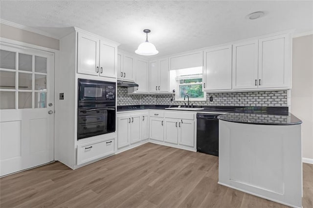 kitchen featuring hanging light fixtures, white cabinets, sink, light hardwood / wood-style floors, and black appliances