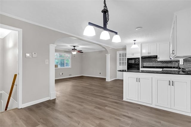 kitchen featuring backsplash, black appliances, white cabinets, hardwood / wood-style floors, and decorative light fixtures