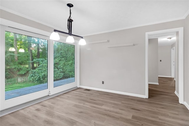 unfurnished dining area featuring ornamental molding and hardwood / wood-style flooring