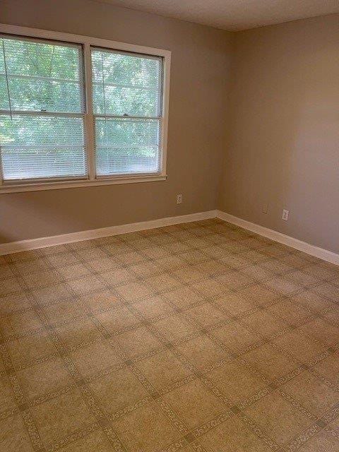 empty room with baseboards and a textured ceiling