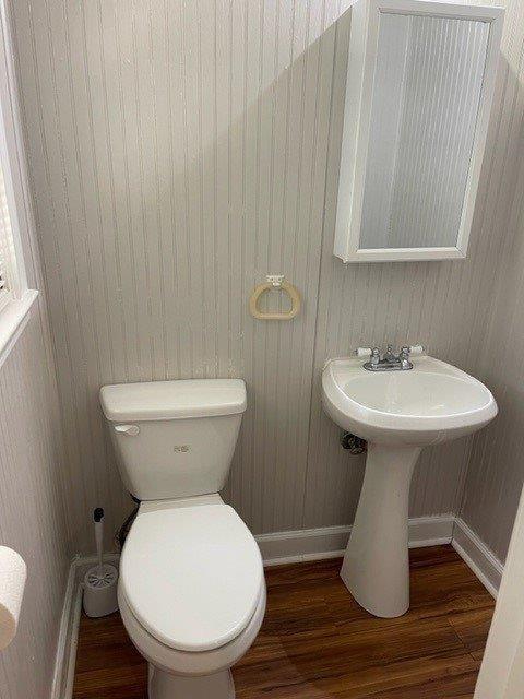 bathroom featuring baseboards, toilet, and wood finished floors