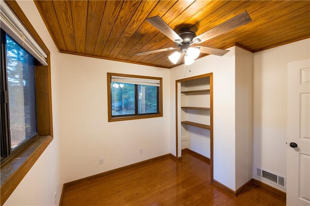 unfurnished bedroom with wood ceiling, multiple windows, dark hardwood / wood-style floors, and ceiling fan