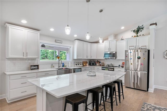 2241 N 16th Hwy, Whitesburg, GA 30185 - kitchen with appliances with stainless steel finishes, a breakfast bar area, white cabinetry, a kitchen island, and tasteful backsplash