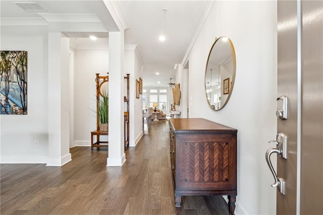 entryway featuring dark hardwood / wood-style floors, crown molding, and decorative columns