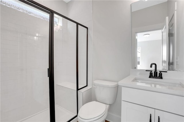 full bathroom featuring a stall shower, vanity, and toilet