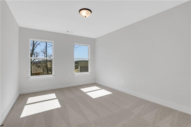 unfurnished room with carpet floors and baseboards