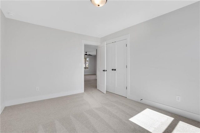 empty room featuring baseboards and light colored carpet