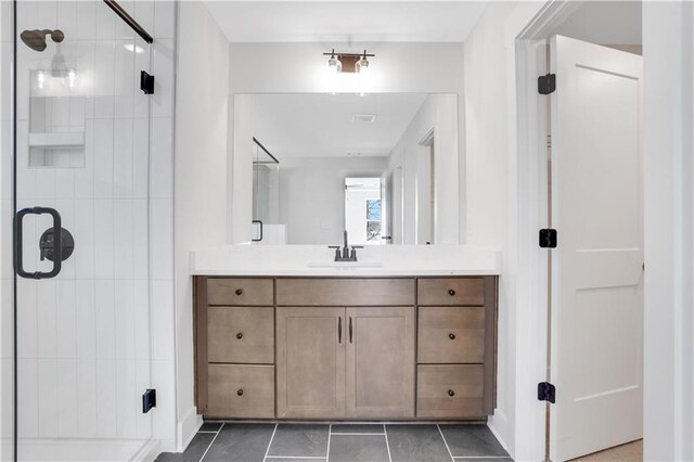 bathroom with tile patterned flooring, vanity, and a shower stall