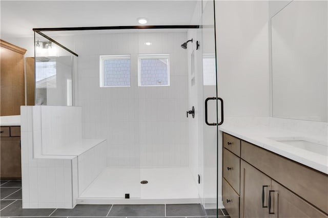 bathroom with tile patterned flooring, vanity, and a shower stall