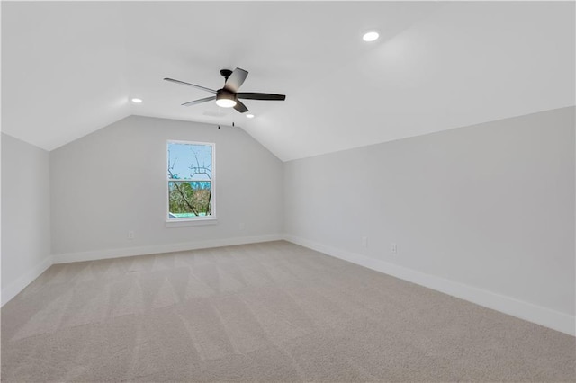 additional living space featuring baseboards, a ceiling fan, light colored carpet, lofted ceiling, and recessed lighting