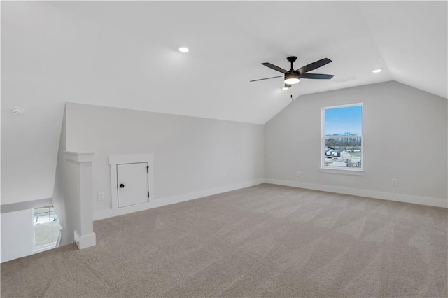 additional living space featuring vaulted ceiling, baseboards, and light colored carpet