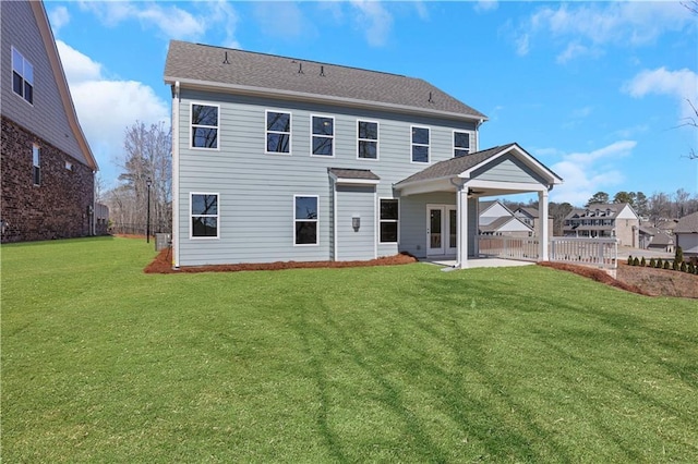 back of property with a lawn, a patio area, and fence