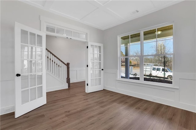 entrance foyer with a decorative wall, a wainscoted wall, dark wood-type flooring, coffered ceiling, and stairway