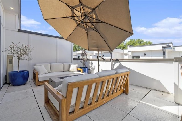 view of patio with an outdoor living space with a fire pit