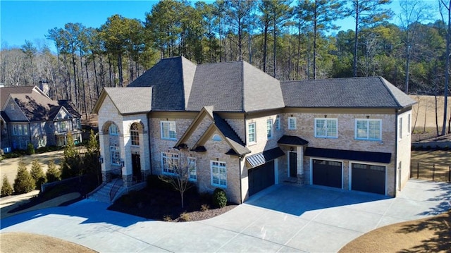 view of front of property featuring a garage, driveway, and a wooded view