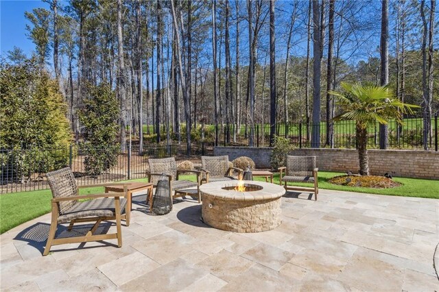 view of patio / terrace featuring fence and a fire pit