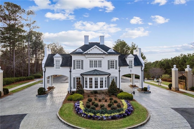 exterior space featuring a chimney, curved driveway, and a carport