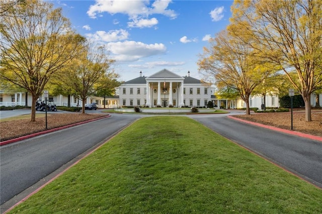 view of front of house featuring a front yard and curved driveway