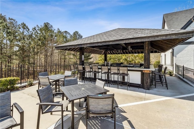 view of patio / terrace featuring a gazebo, fence, and outdoor dry bar