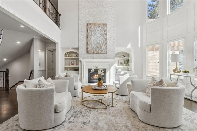 4434 Oglethorpe Loop NW, Acworth, GA 30101 - living room with a high ceiling, built in shelves, wood finished floors, and a lit fireplace
