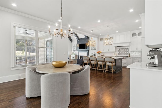 dining area featuring recessed lighting, an inviting chandelier, ornamental molding, and dark wood-style floors