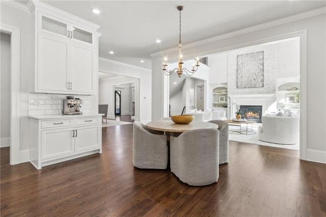 dining room with baseboards, dark wood-style flooring, and a glass covered fireplace