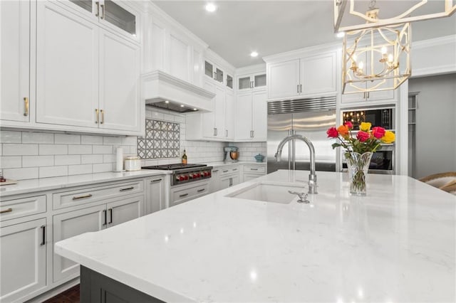 kitchen featuring a sink, a notable chandelier, white cabinets, and appliances with stainless steel finishes