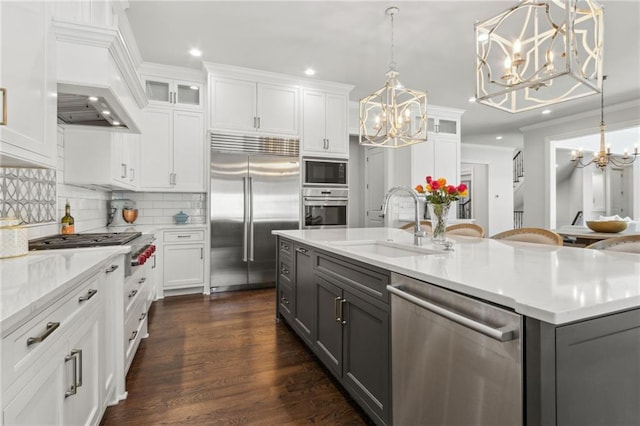 kitchen featuring an inviting chandelier, gray cabinets, and built in appliances