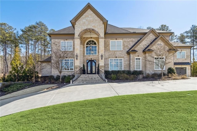 french provincial home with brick siding and a front lawn