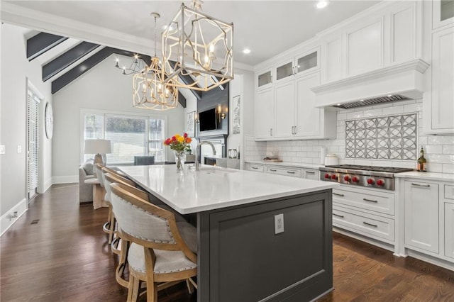 kitchen with an inviting chandelier, light countertops, tasteful backsplash, and stainless steel gas cooktop