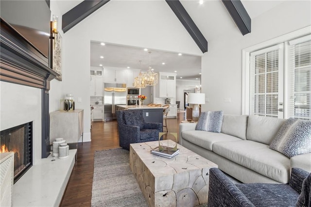 living room with a premium fireplace, a notable chandelier, dark wood-style floors, and beam ceiling