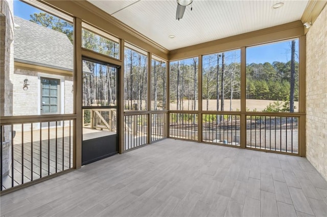 unfurnished sunroom featuring a ceiling fan