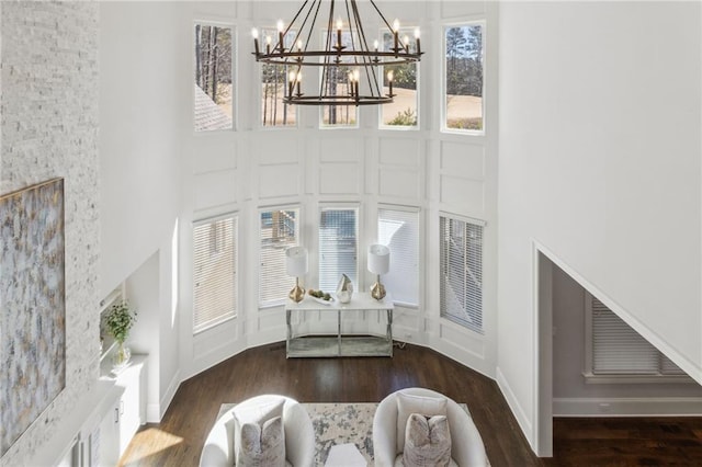 entrance foyer with plenty of natural light, an inviting chandelier, a high ceiling, and wood finished floors
