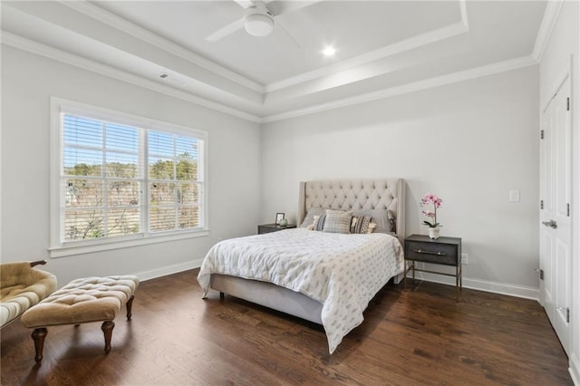 bedroom featuring baseboards, a raised ceiling, crown molding, and wood finished floors