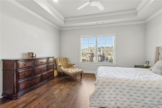 bedroom with a tray ceiling, dark wood-type flooring, baseboards, and ornamental molding