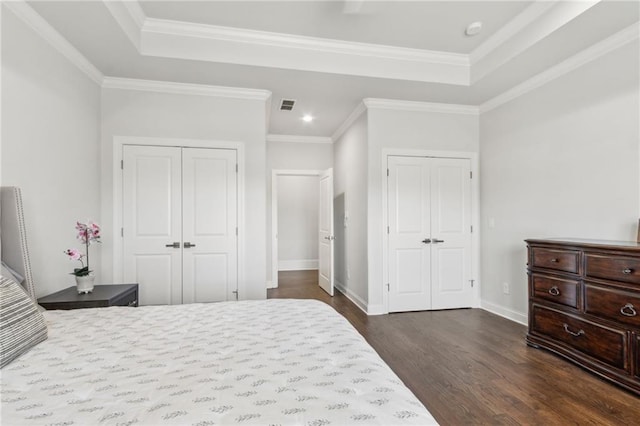 4434 Oglethorpe Loop NW, Acworth, GA 30101 - bedroom featuring two closets, dark wood-style flooring, a raised ceiling, baseboards, and crown molding