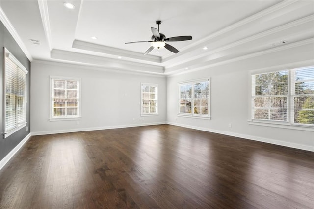 unfurnished room featuring a wealth of natural light, a tray ceiling, crown molding, and dark wood-type flooring