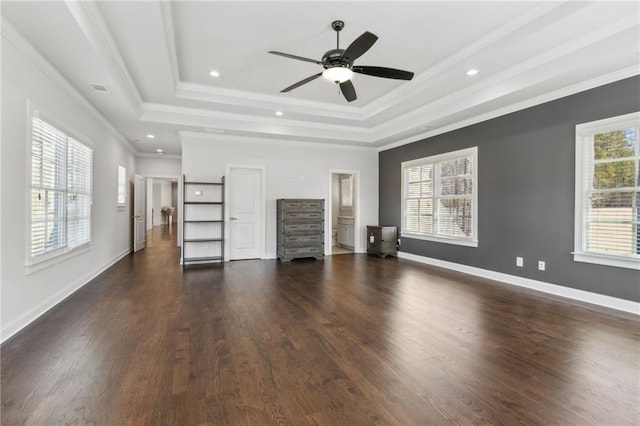 unfurnished living room with a tray ceiling, dark wood-type flooring, baseboards, and a ceiling fan