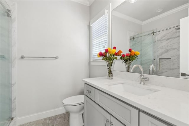 bathroom with a stall shower, toilet, vanity, and crown molding