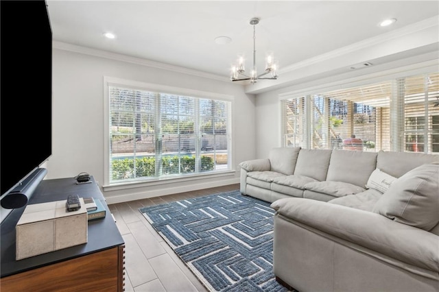 living area with recessed lighting, an inviting chandelier, and crown molding