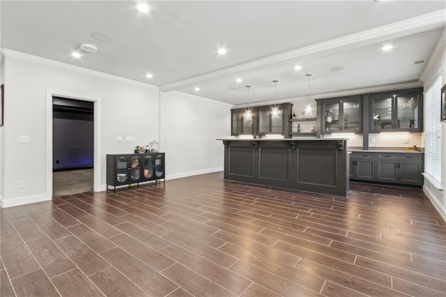 kitchen featuring gray cabinetry, dark wood finished floors, ornamental molding, and a kitchen island with sink