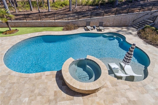 view of swimming pool featuring a patio area, a pool with connected hot tub, and fence